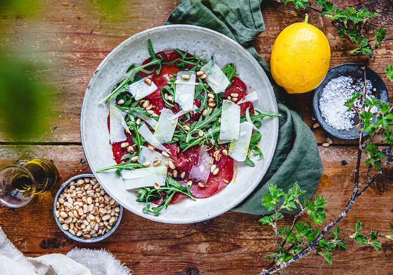 Sallad med bresaola pinjenötter och citron på fat